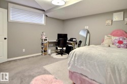 Carpeted room featuring a white door with black hardware, a high horizontal window with blinds, light gray wall paint, and white baseboards - 
