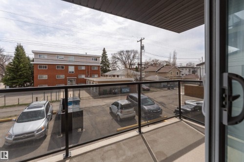 Balcony featuring a concrete floor, dark metal railing, and clear glass panels - 203 10003 87 Avenue, Edmonton, AB - Outdoor With Exterior