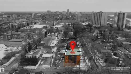 The property features a multi-story building with a brick exterior, situated within a neighborhood of residential buildings - 203 10003 87 Avenue, Edmonton, AB - Outdoor With View