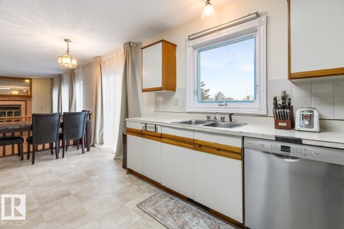 Kitchen area featuring a double basin sink, white countertops, and a stainless steel dishwasher - 4340 33 Street, Edmonton, AB - Indoor Photo Showing Kitchen With Double Sink