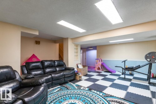 Spacious lower level featuring recessed lighting, a neutral color palette, built-in shelving, and a combination of carpeted and checkerboard flooring - 4340 33 Street, Edmonton, AB - Indoor Photo Showing Basement