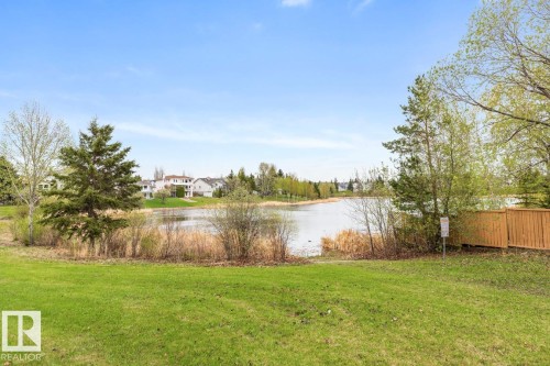 Expansive green lawn bordering a body of water with natural reeds - 4340 33 Street, Edmonton, AB - Outdoor With View
