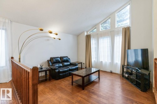 Living area featuring hardwood flooring and a wooden railing - 4340 33 Street, Edmonton, AB - Indoor Photo Showing Living Room