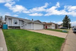 Light blue siding exterior featuring a prominent bay window and an attached garage with a white door - 