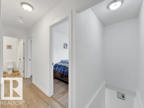 Hallway featuring wood-finish flooring, flush-mount lighting, and white baseboards - 3602 50Th Ave, Sylvan Lake, AB - Indoor Photo Showing Other Room