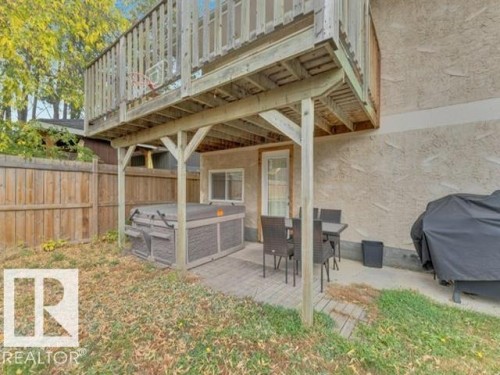 Spacious outdoor area with a ground-level deck, a built-in spa, and a private wooden fence - 3602 50Th Ave, Sylvan Lake, AB - Outdoor