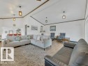 Spacious room featuring vaulted ceilings, wood-finish flooring, white walls, and dark trim accents - 3602 50Th Ave, Sylvan Lake, AB  - Indoor Photo Showing Living Room 