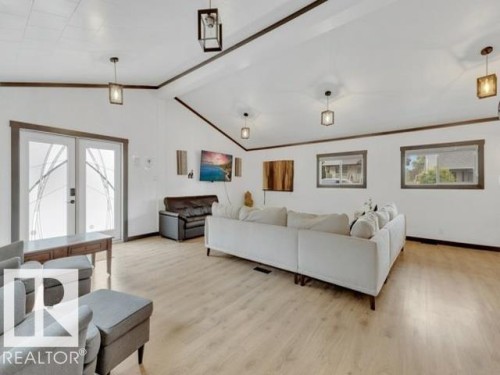 Spacious living area featuring vaulted ceilings with exposed beams, light wood-finish flooring, and multiple windows - 3602 50Th Ave, Sylvan Lake, AB - Indoor Photo Showing Living Room
