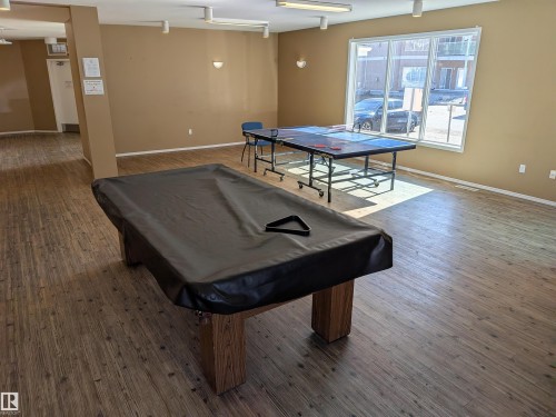Recreation room featuring wood-finish flooring, a covered billiards table, and a ping-pong table - 419 4304 139 Avenue, Edmonton, AB - Indoor Photo Showing Other Room