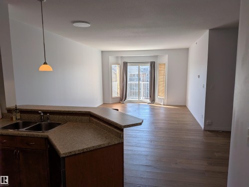 Bright South Facing Living room provides lots of sunlight with sliding glass doors to a private balcony. - 419 4304 139 Avenue, Edmonton, AB - Indoor Photo Showing Kitchen With Double Sink