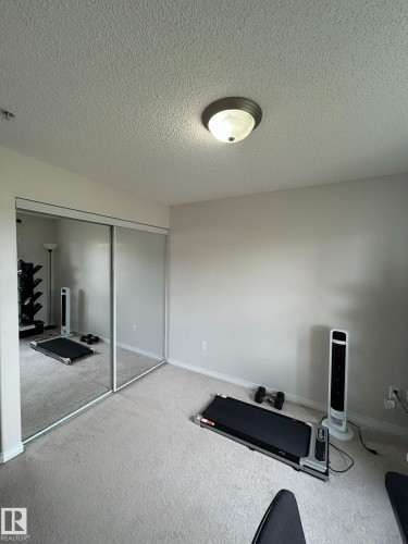 Recessed lighting fixture illuminating a room with neutral-toned carpet flooring and light-colored walls - 1228 9363 Simpson Drive, Edmonton, AB - Indoor