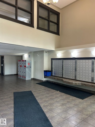 Lobby area featuring parcel lockers and individual mailboxes with a stone-finish countertop - 1228 9363 Simpson Drive, Edmonton, AB - Indoor Photo Showing Other Room