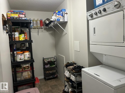 Dedicated laundry space featuring a white stacked washer and dryer unit - 1228 9363 Simpson Drive, Edmonton, AB - Indoor Photo Showing Laundry Room