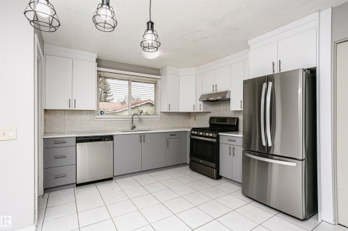 Spacious country kitchen with large dinette area & st/steel appliances. Beautiful new custom cabinetry and quartz countertops. Undermount st/st farmhouse sink & new faucet. Tile backsplash. New st/st fridge and dishwasher. Gas stove and hood fan. - 11436 161 Avenue, Edmonton, AB - Indoor Photo Showing Kitchen
