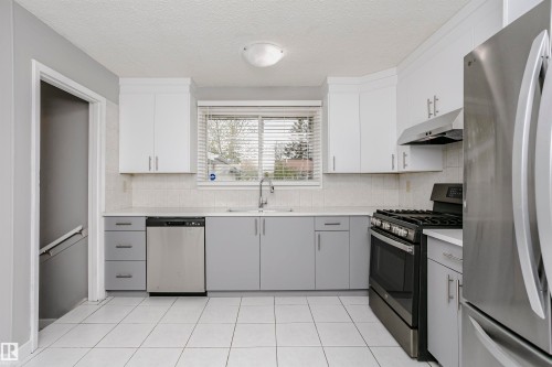 Spacious country kitchen with large dinette area & st/steel appliances. Beautiful new custom cabinetry and quartz countertops. Undermount st/st farmhouse sink & new faucet. Tile backsplash. New st/st fridge and dishwasher. Gas stove and hood fan. - 11436 161 Avenue, Edmonton, AB - Indoor Photo Showing Kitchen