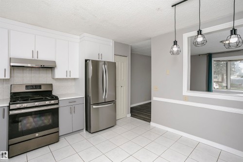 Enjoy added natural light from cut through to living room into kitchen and dinette area. Attractive lighting has been upgraded. - 11436 161 Avenue, Edmonton, AB - Indoor Photo Showing Kitchen