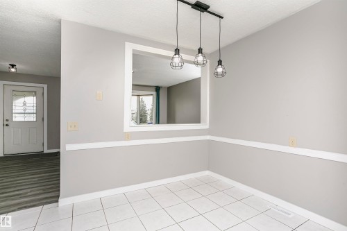 Spacious eat in dinette area with attractive lighting in kitchen. Tile flooring and convenient cut through to living room adds natural light. - 11436 161 Avenue, Edmonton, AB - Indoor Photo Showing Other Room