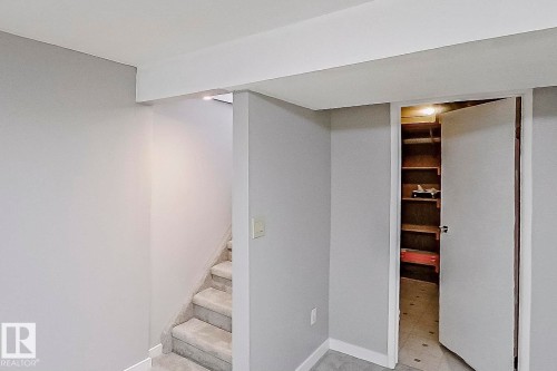 Staircase to basement with new plush carpet. This rear entry would be ideal for a future suite. Storage room is on the right. - 11436 161 Avenue, Edmonton, AB - Indoor Photo Showing Other Room