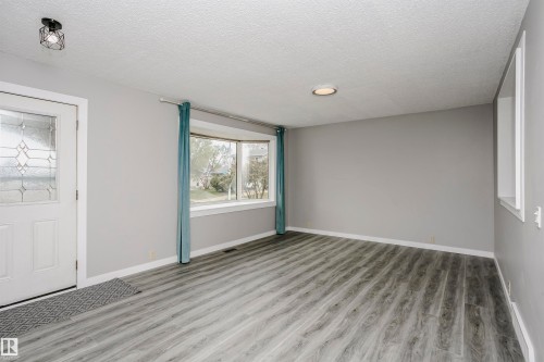 Bay window in living room. Beautiful new vinyl plank flooring in front entry and throughout main floor.  Tile in kitchen and bathrooms. Freshly painted throughout and new lighting. - 11436 161 Avenue, Edmonton, AB - Indoor Photo Showing Other Room