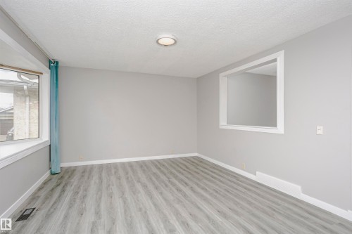 Bay window in living room.  Beautiful new vinyl plank flooring. Convenient cut through in wall to kitchen and dinette area for added natural light. Freshly painted throughout and new lighting. - 11436 161 Avenue, Edmonton, AB - Indoor Photo Showing Other Room