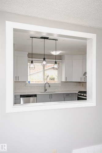 Convenient cut through window from living room into kitchen and dinette area adds natural light. - 11436 161 Avenue, Edmonton, AB - Indoor Photo Showing Kitchen