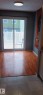 Wood-finish flooring and neutral-toned walls, illuminated by a ceiling-mounted light fixture - 2554 79 Street, Edmonton, AB  - Indoor Photo Showing Other Room 
