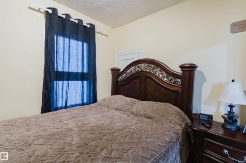 Window with privacy curtains, light-toned walls, and a textured ceiling - 10834 75 Avenue, Edmonton, AB - Indoor Photo Showing Bedroom