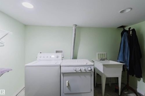 Dedicated laundry area featuring a utility sink, overhead shelving, and recessed lighting - 10834 75 Avenue, Edmonton, AB - Indoor Photo Showing Laundry Room