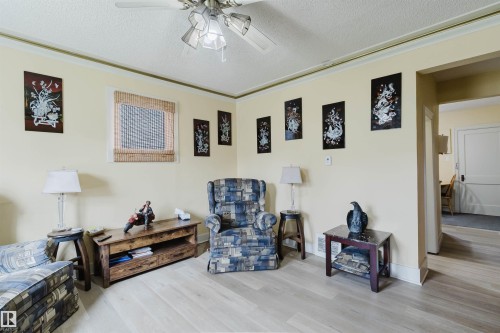 Living area featuring light wood-finish flooring, a ceiling fan with light fixture, and crown molding - 10834 75 Avenue, Edmonton, AB - Indoor