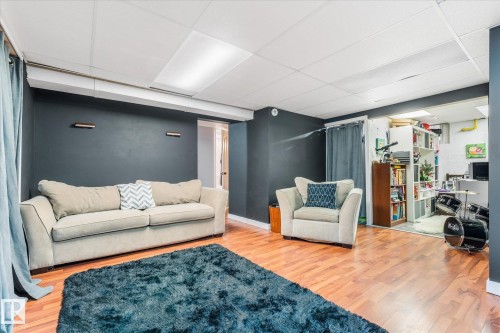 Spacious room featuring wood-finish flooring, dark accent walls, and recessed ceiling lighting - 4759 48 Street, Onoway, AB - Indoor