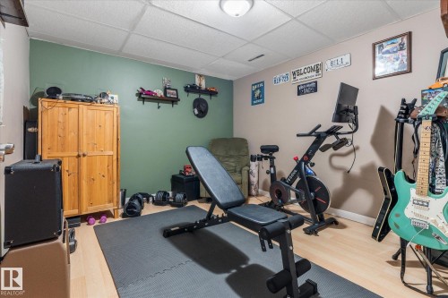 Finished room with light wood-finish flooring, a drop ceiling, and a flush mount light fixture - 4759 48 Street, Onoway, AB - Indoor Photo Showing Gym Room