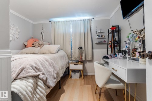 Light wood-finish flooring, white wall paneling, and a single window with drapes - 4759 48 Street, Onoway, AB - Indoor Photo Showing Bedroom