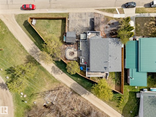 Aerial view showcasing the property's perimeter fencing, an expansive deck, and a fire pit area - 4759 48 Street, Onoway, AB - Outdoor