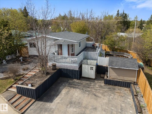 Raised deck with white railing, a separate storage shed, and a detached single-car garage - 4759 48 Street, Onoway, AB - Outdoor With Deck Patio Veranda