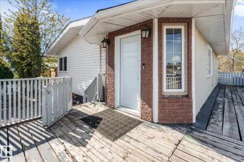 Exterior entrance featuring a white panel door, brick facade, and an outdoor wall sconce - 4759 48 Street, Onoway, AB - Outdoor With Deck Patio Veranda With Exterior