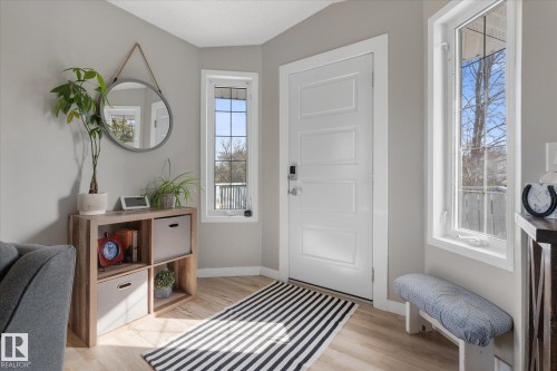 Entryway featuring a paneled door with smart lock, light wood-finish flooring, and multiple casement windows providing natural light - 4759 48 Street, Onoway, AB - Indoor