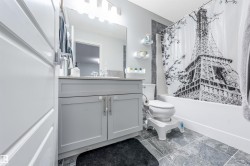 Full bathroom featuring a single vanity with gray cabinetry, a rectangular sink, and a light-colored countertop - 