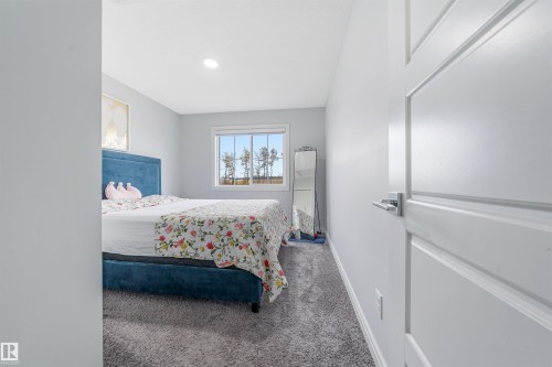 Bedroom featuring a window with exterior scenery, recessed lighting, light gray walls, and gray carpet flooring - 1024 Daniels Loop, Edmonton, AB 