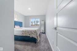 Bedroom featuring a window with exterior scenery, recessed lighting, light gray walls, and gray carpet flooring - 