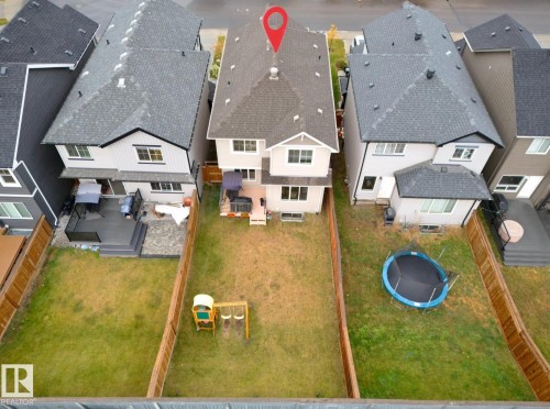 Rear exterior featuring a multi-level deck, ground-level patio, and a spacious grassy yard - 1024 Daniels Loop, Edmonton, AB 