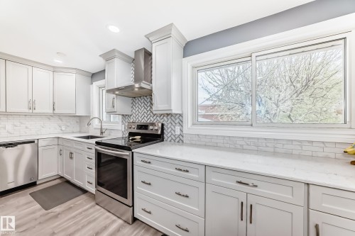 Modern kitchen featuring light gray cabinetry, white countertops, and stainless steel appliances - 4006 115 Avenue, Edmonton, AB 