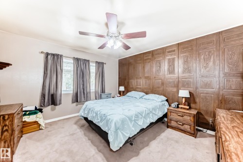 Room featuring decorative wood paneling, light-colored carpeting, and a ceiling fan with integrated lighting - 4006 115 Avenue, Edmonton, AB 