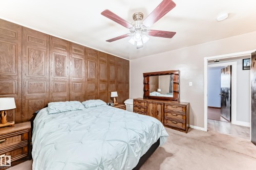 Panel accent wall with a ceiling fan light fixture and neutral-toned carpeting - 4006 115 Avenue, Edmonton, AB 