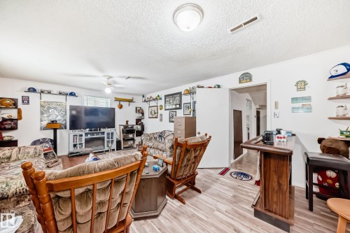 Spacious recreation room featuring wood-finish flooring and a built-in bar - 4006 115 Avenue, Edmonton, AB 