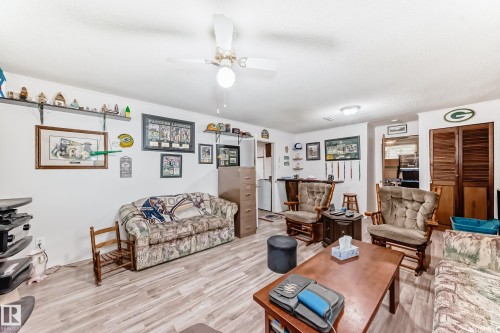 Spacious common area featuring wood-finish flooring, a ceiling fan, and recessed lighting - 4006 115 Avenue, Edmonton, AB 