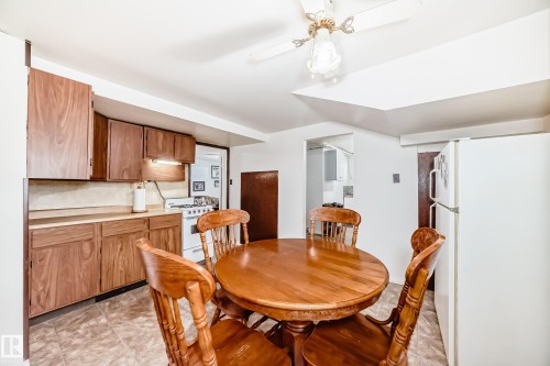 Functional kitchen with wood-finish cabinetry and a white gas range - 4006 115 Avenue, Edmonton, AB 