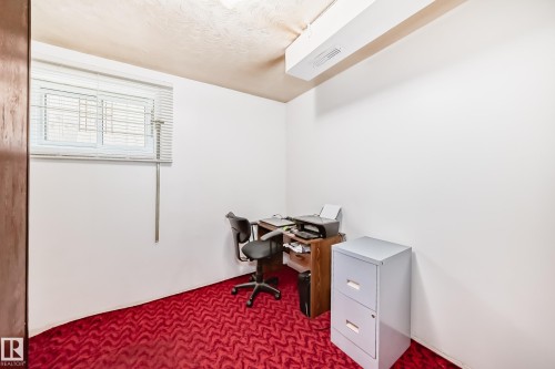 Room featuring a patterned red carpet, white walls, and a window with horizontal blinds - 4006 115 Avenue, Edmonton, AB 