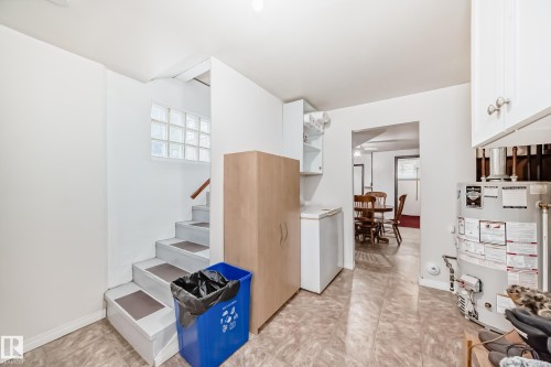 Interior space with light-toned flooring, white walls, and a staircase featuring glass block accents - 4006 115 Avenue, Edmonton, AB 