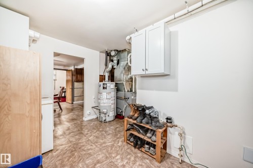 Basement utility area featuring tiled flooring, a water heater, and an exposed HVAC system - 4006 115 Avenue, Edmonton, AB 