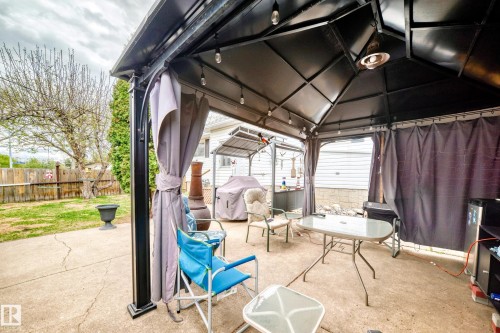 Patio with a black metal gazebo featuring string lighting and an overhead heater - 4006 115 Avenue, Edmonton, AB 